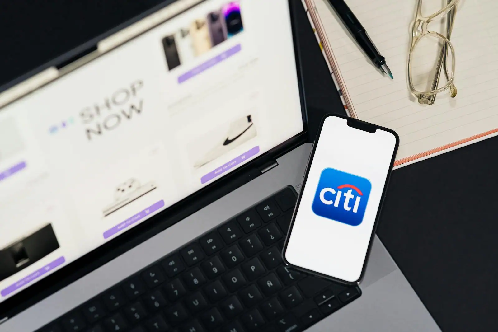 Personne comparant des offres bancaires sur un smartphone et un ordinateur