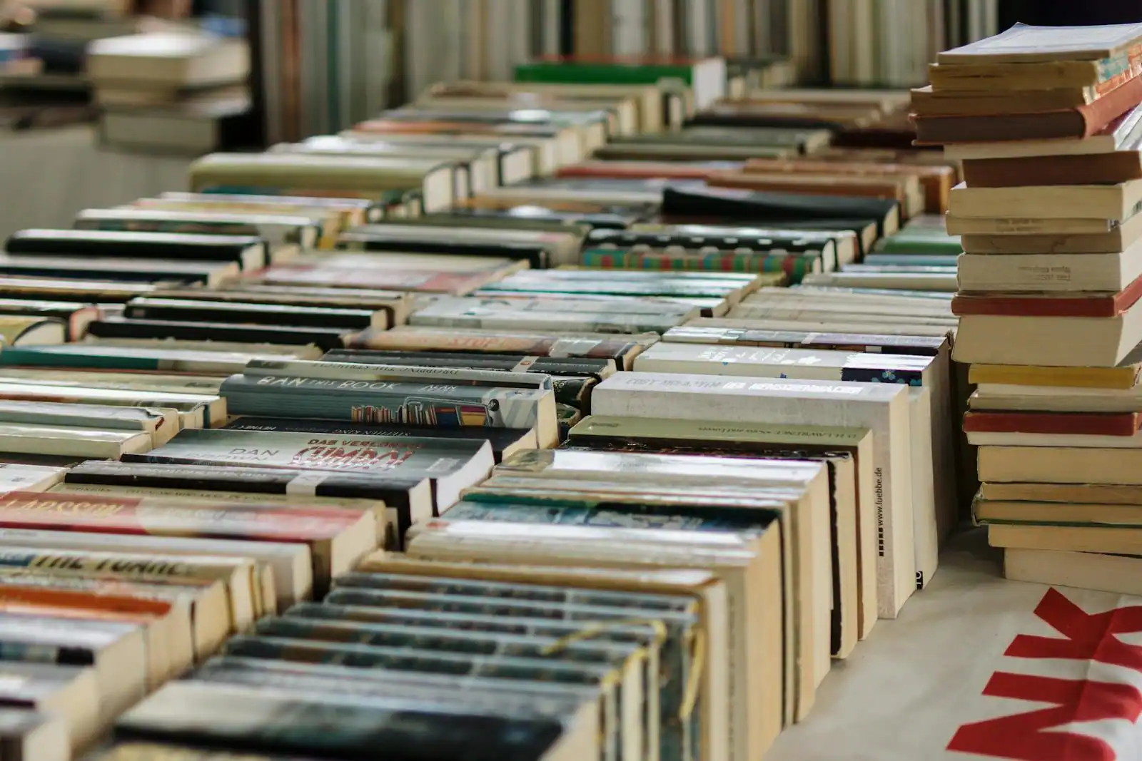 Pile de livres d'occasion sur un étal de bourse aux livres, étiquettes de prix visibles