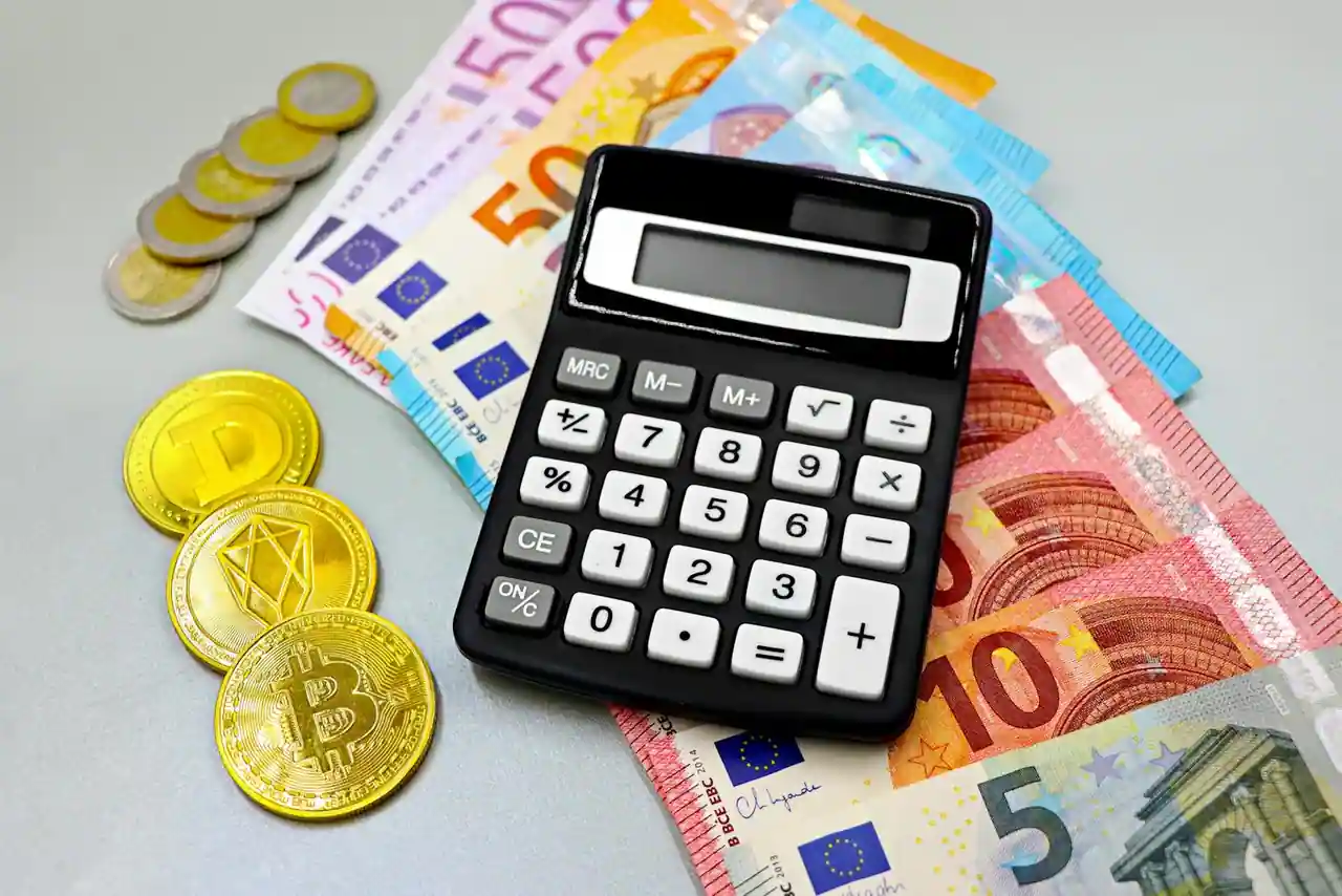 Billets en euros, pièces de monnaie et calculatrice illustrant la conversion de devises