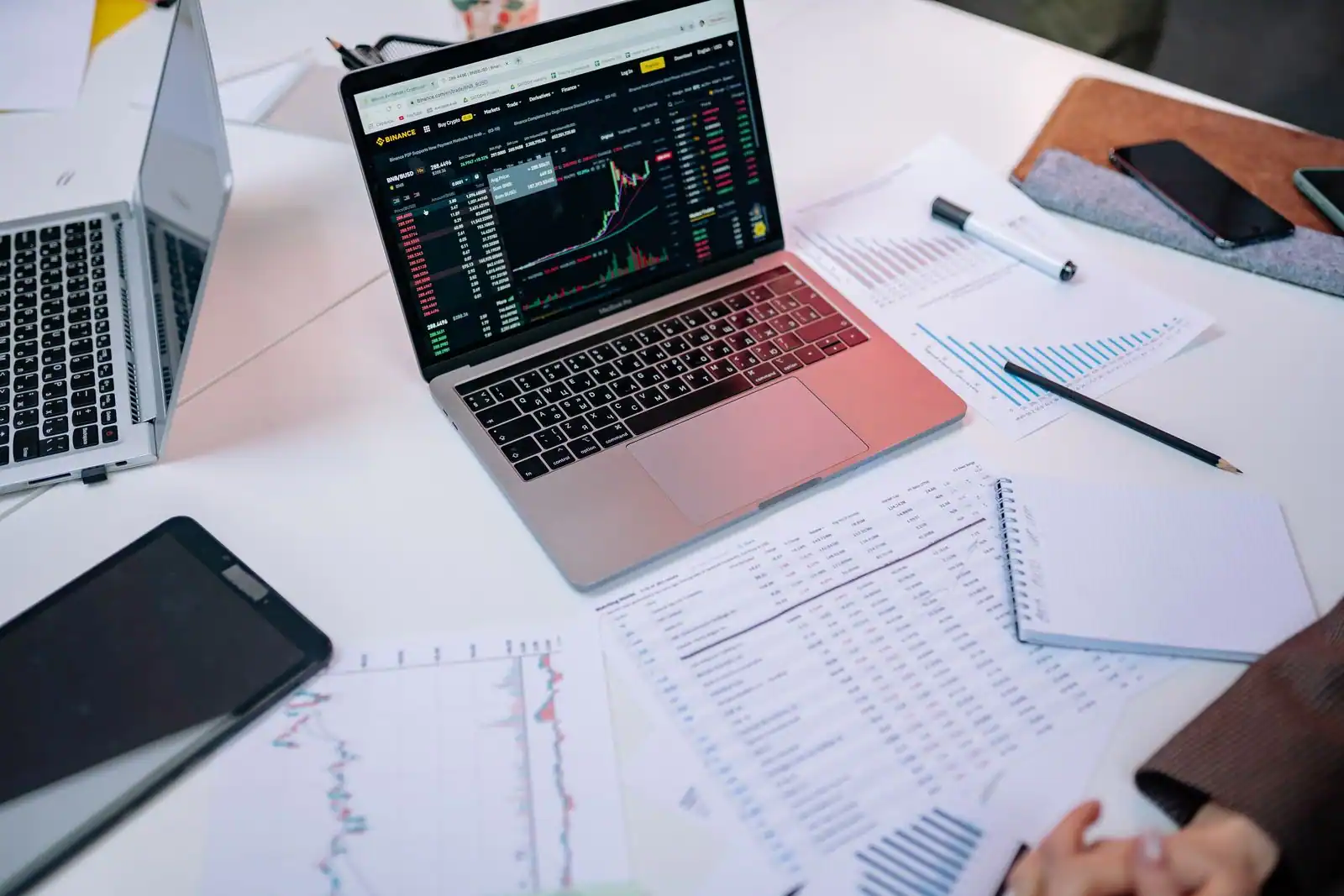 Personne analysant des documents et des données financières sur un écran et sur papier