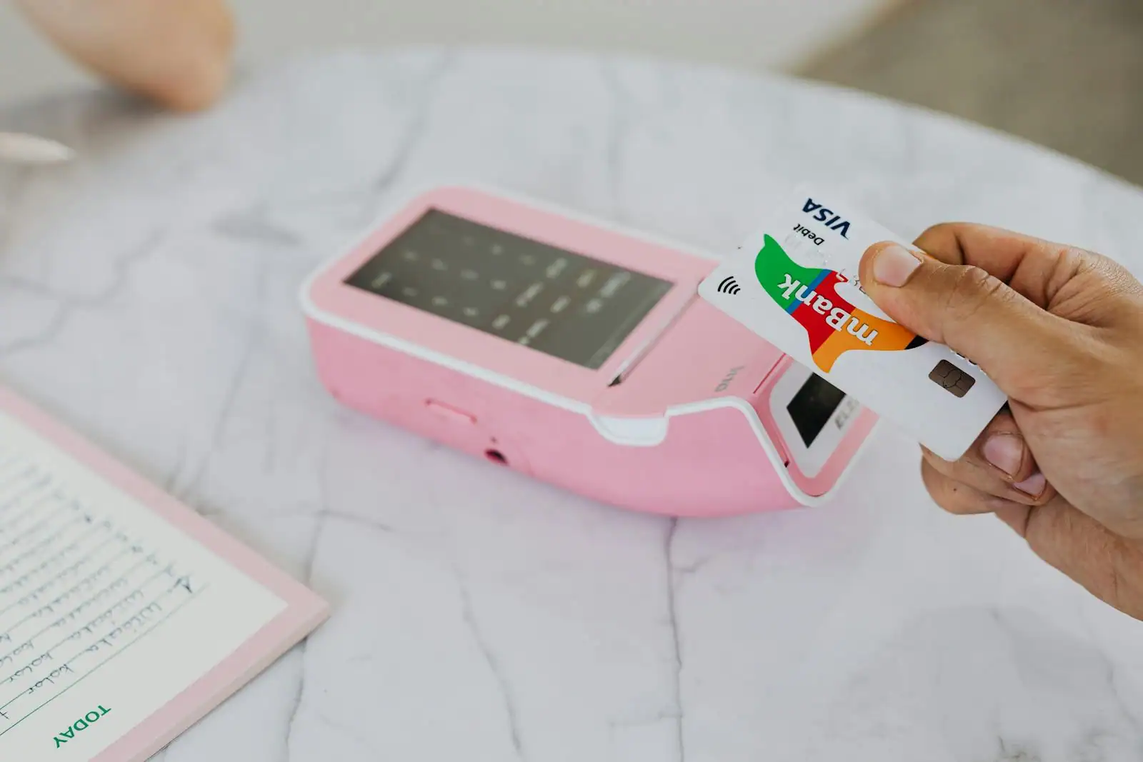 Smartphone affichant une application de gestion de compte et carte de paiement posés sur un bureau