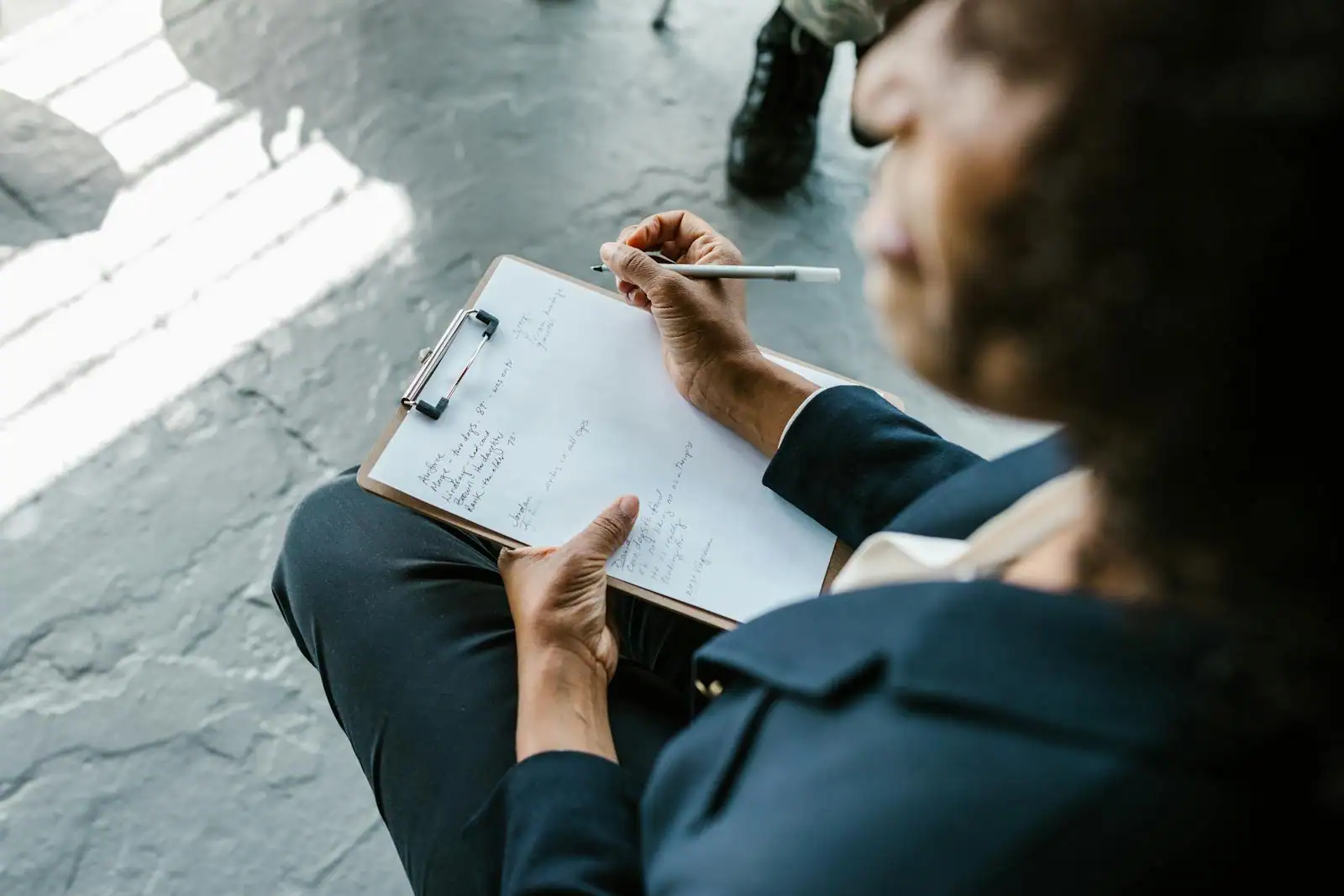 Personne en entretien d'accompagnement professionnel prenant des notes face à une conseillère