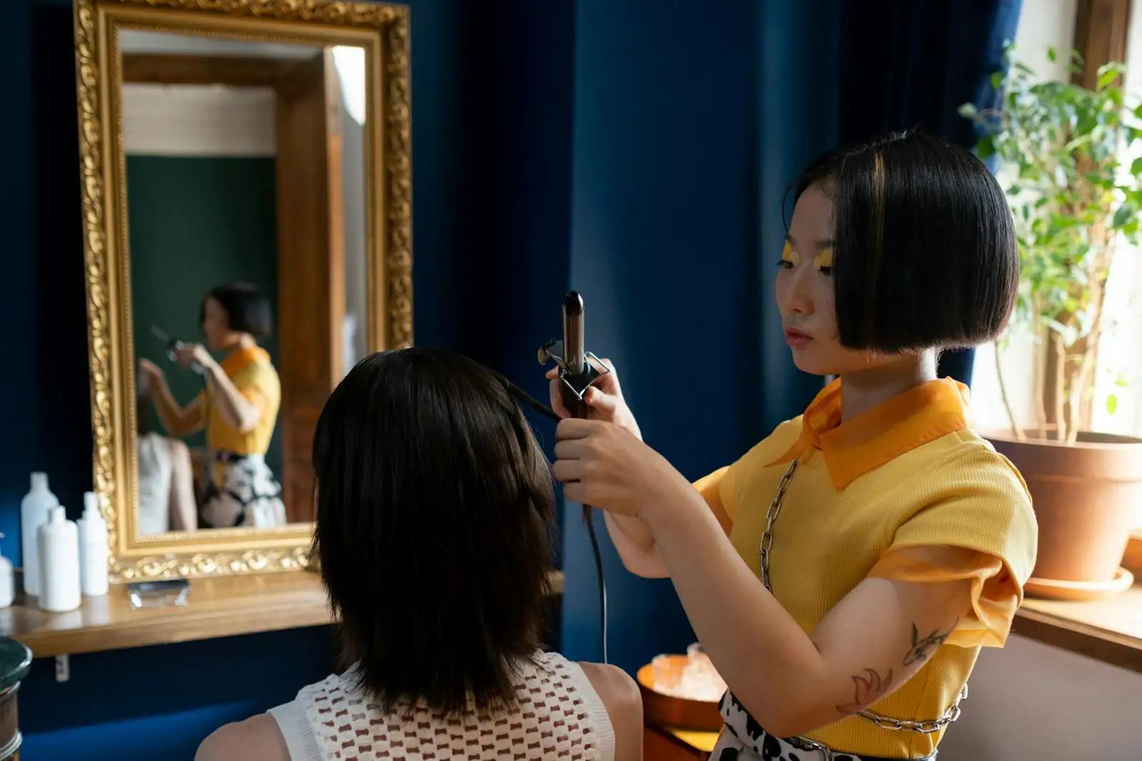 Coiffeuse coiffant une cliente dans un salon de coiffure clair et moderne récemment ouvert
