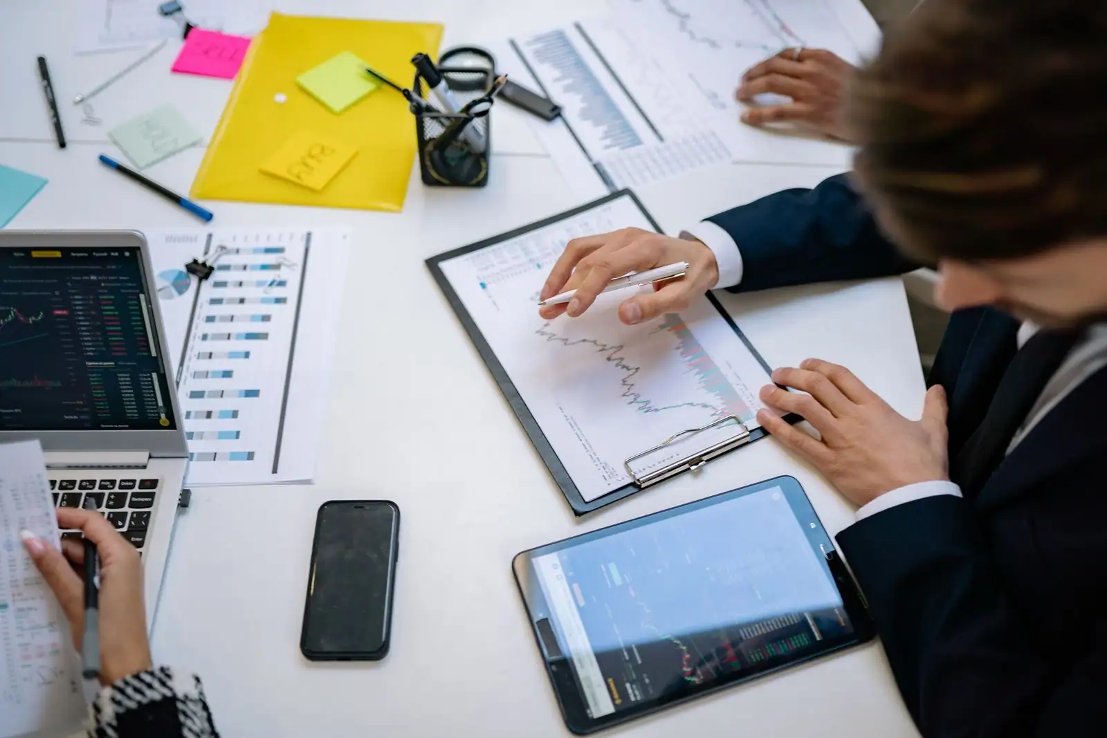 Des professionnels analysent des graphiques de croissance et des tableaux de chiffres autour d'une table de travail.