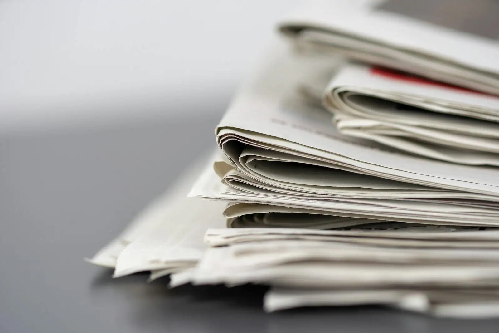 Pile de journaux pliés posés sur une surface claire