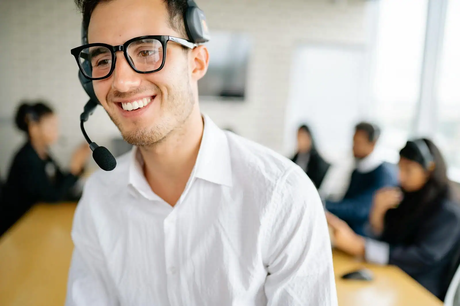 Conseillère souriante au téléphone avec un casque dans un bureau lumineux, en pleine relation clientèle