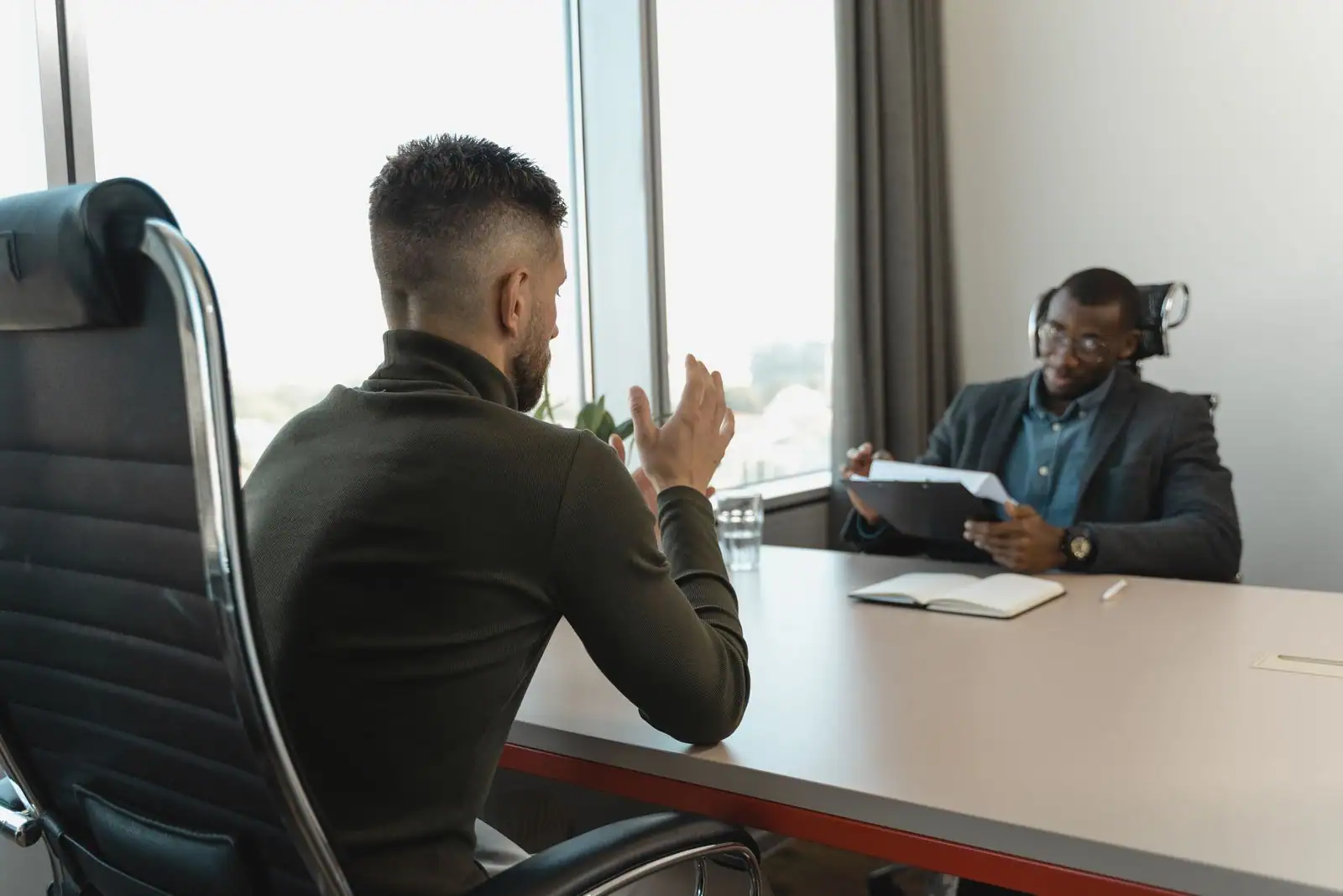 Entretien d'embauche dans un bureau : un candidat échange avec un recruteur de part et d'autre d'une table