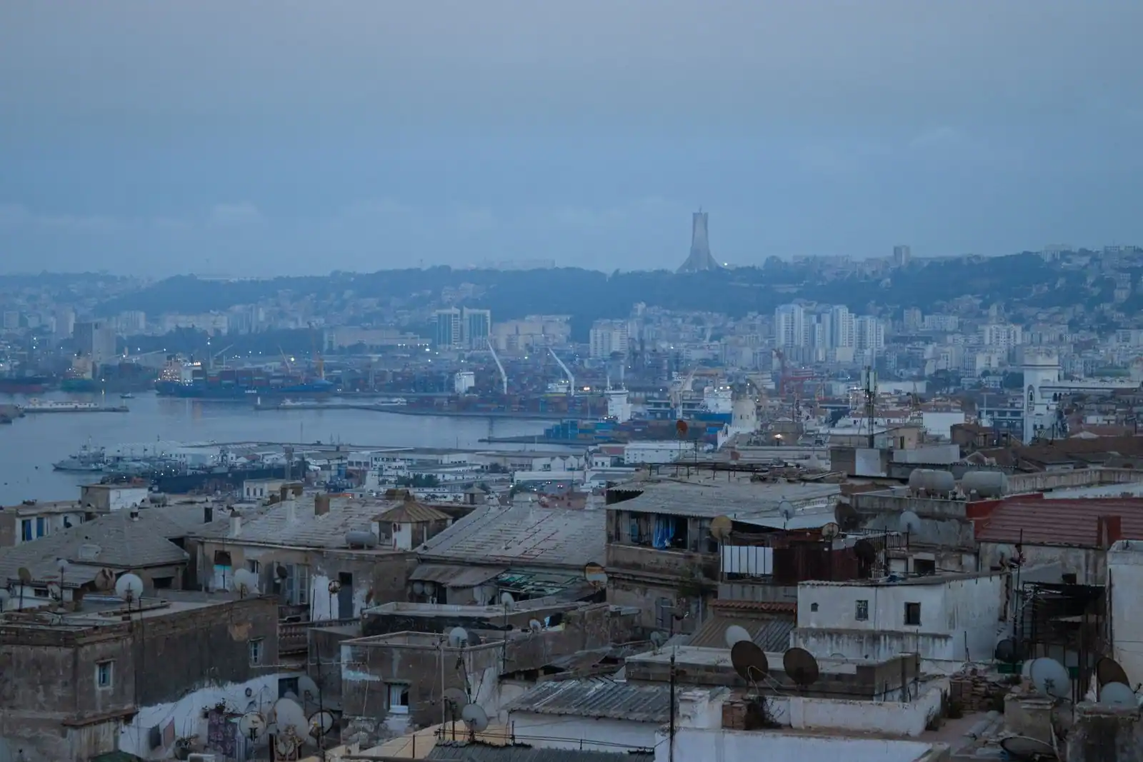 Panorama d’Alger au crépuscule : les toits de la vieille ville, le port et la baie