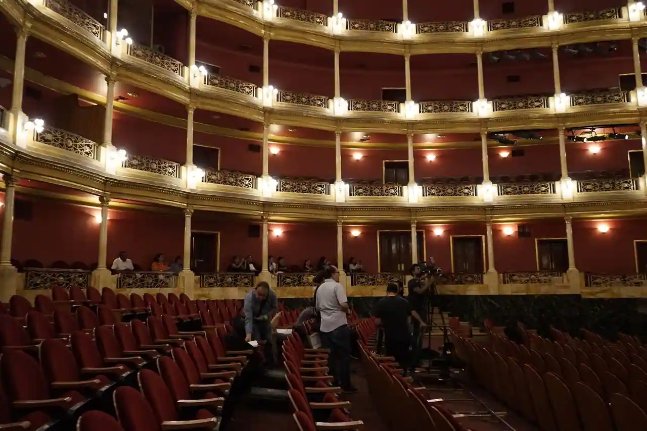 Salle de spectacle à l'italienne avec rangées de fauteuils rouges et balcons