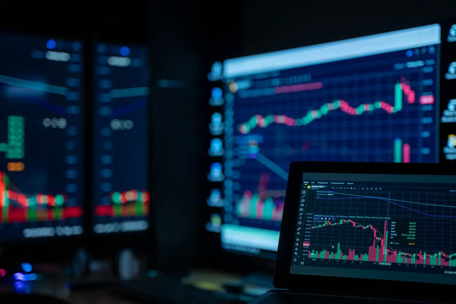 Écrans de trading affichant des graphiques de marché en chandeliers, évocation d'une plateforme de courtage en ligne.