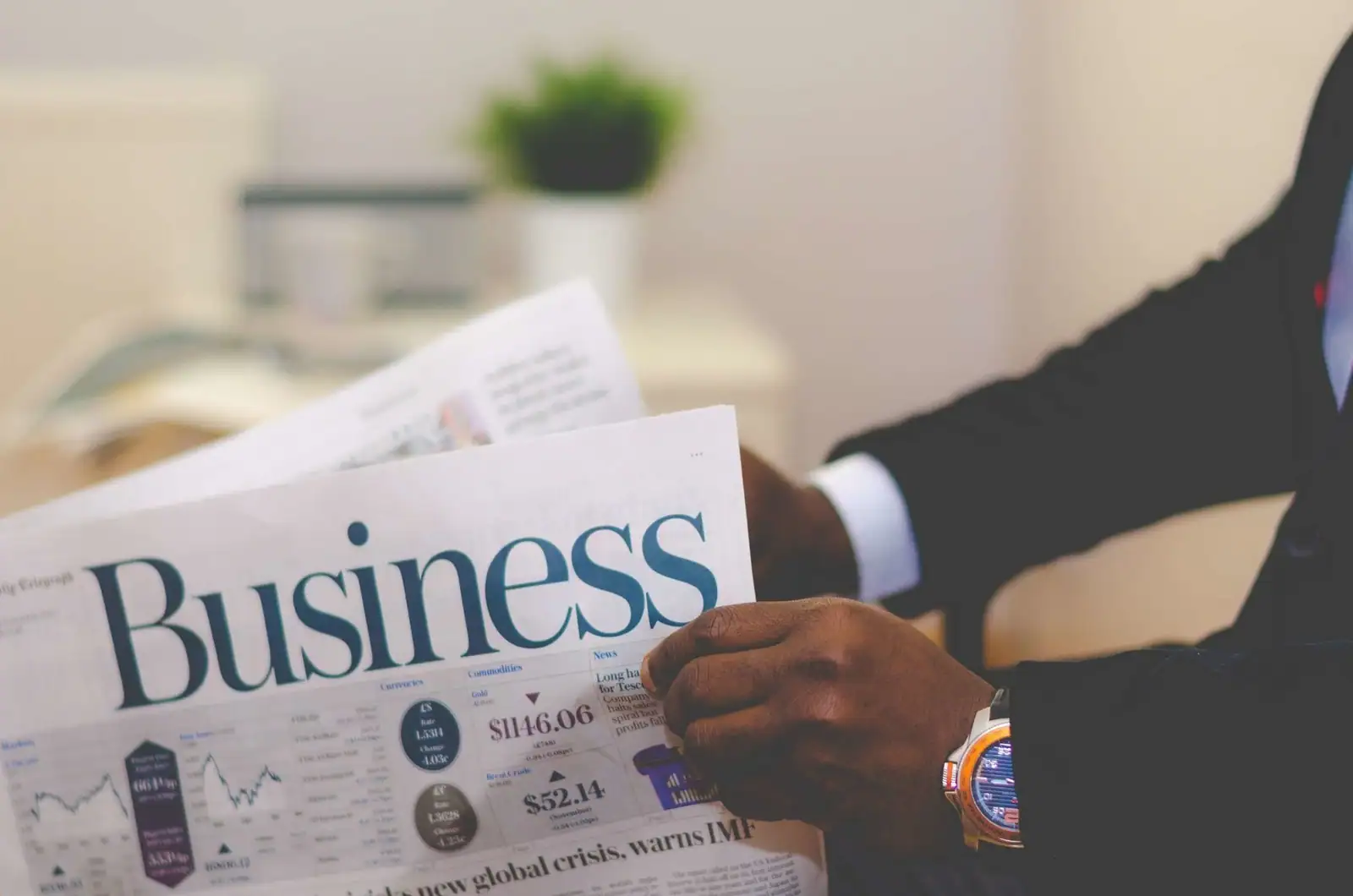 Un lecteur en costume parcourt la rubrique « Business » d'un journal, illustrant le suivi de l'actualité économique.