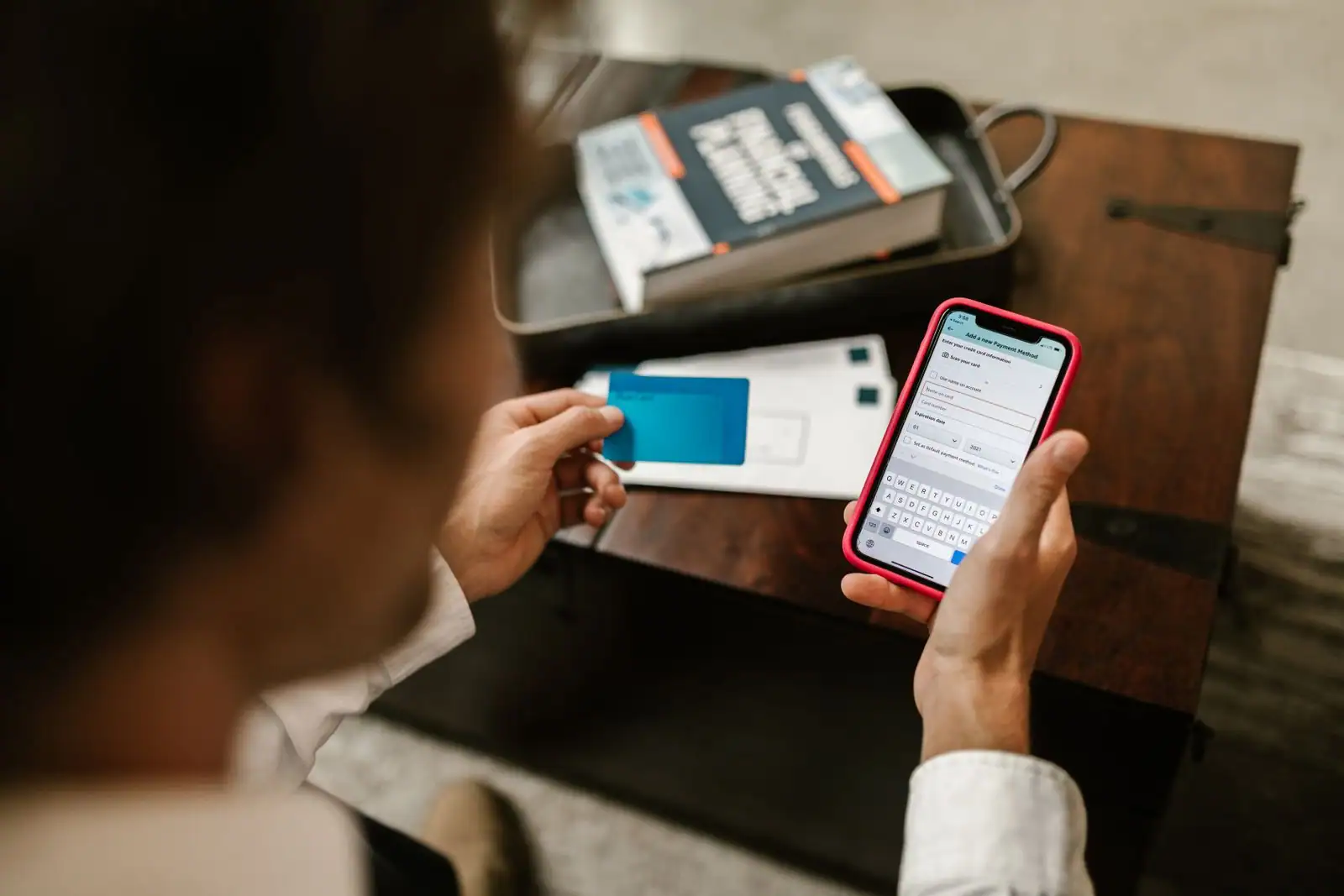 Une personne consulte son compte bancaire en ligne sur un smartphone, à la maison