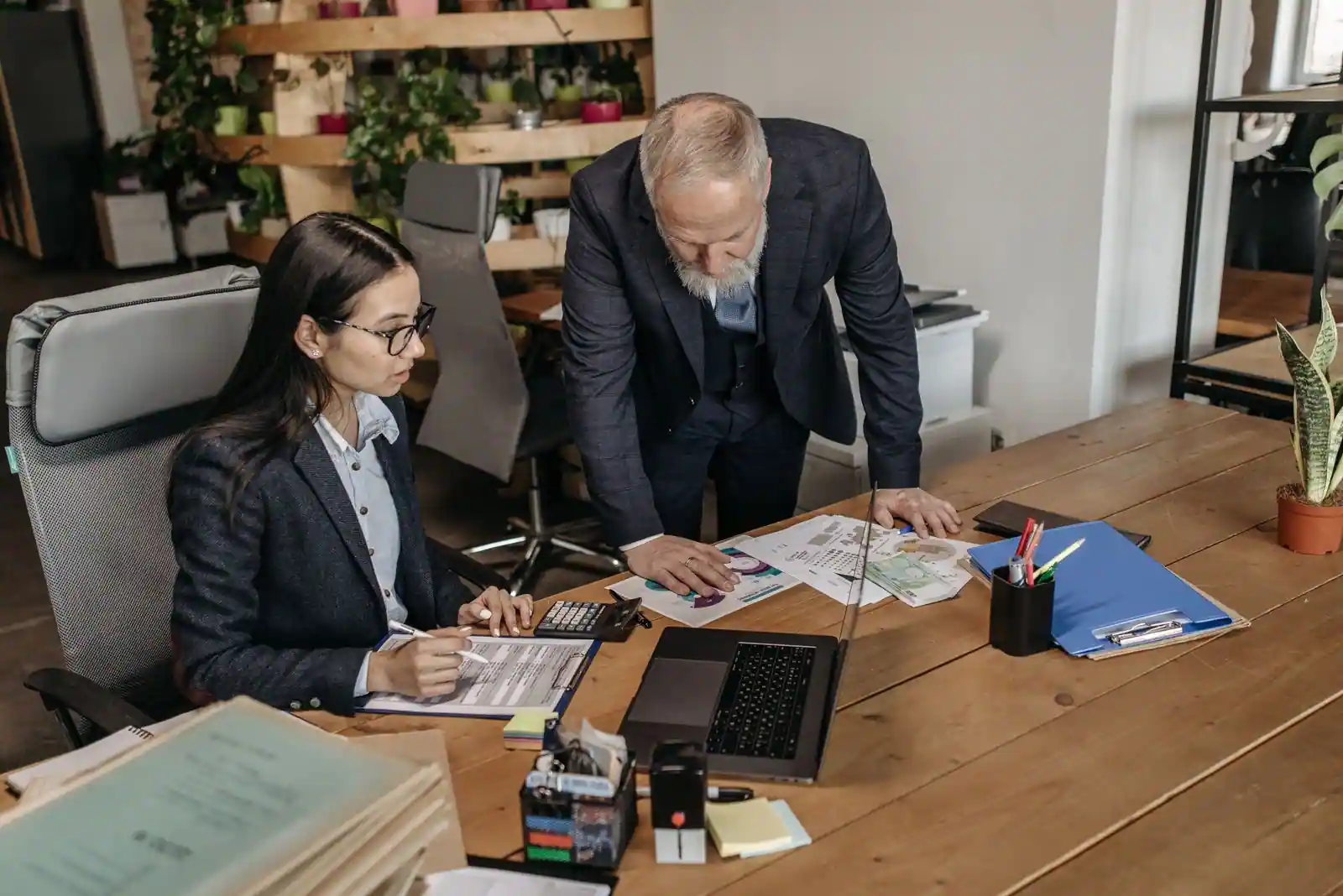 Un salarié et un responsable en entretien au bureau, échangeant autour d'un document de travail.