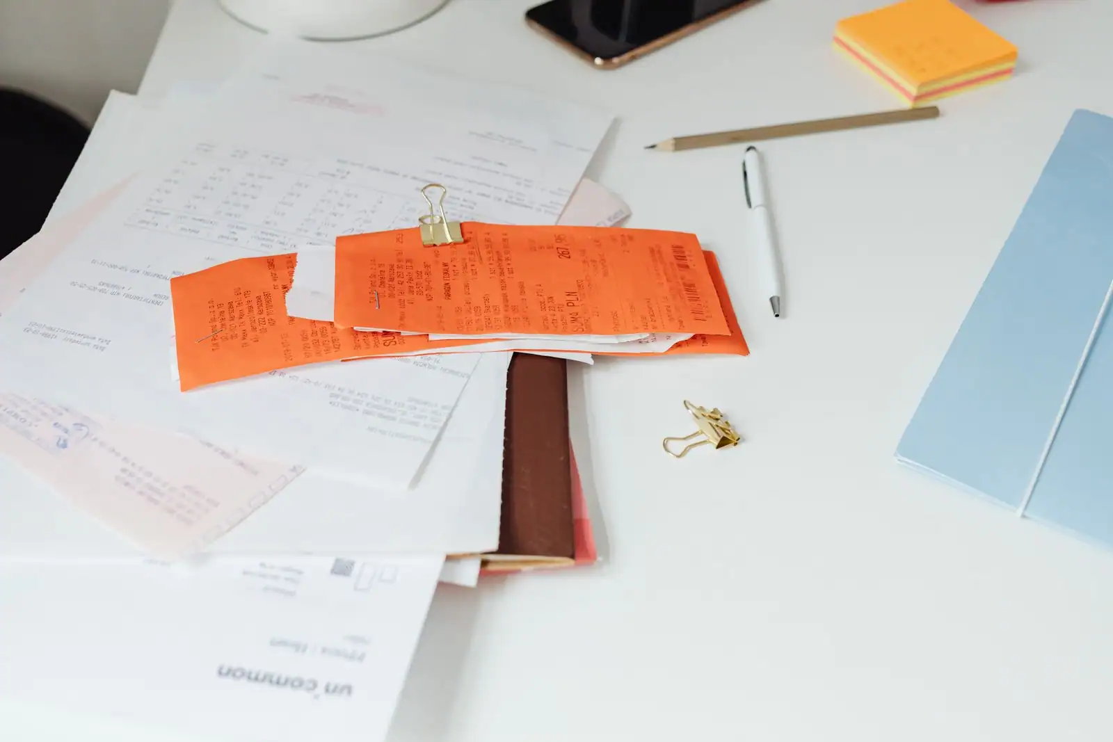 Relevés, courriers et papiers administratifs éparpillés sur un bureau.