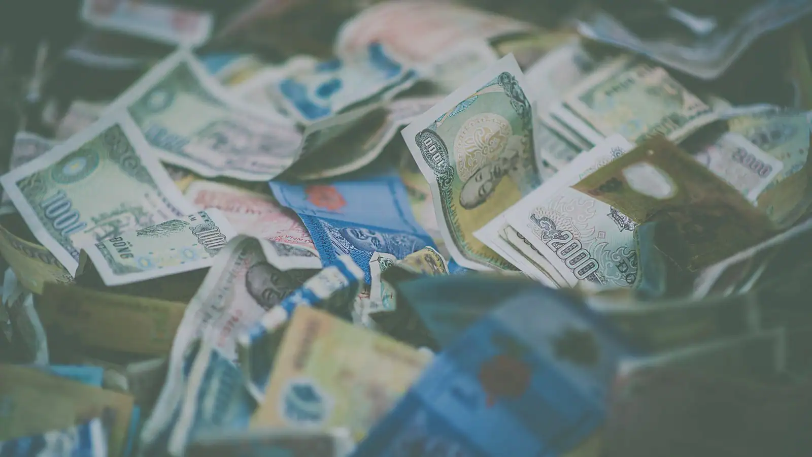 Billets de banque de différentes devises étrangères mêlés, évoquant la conversion entre monnaies