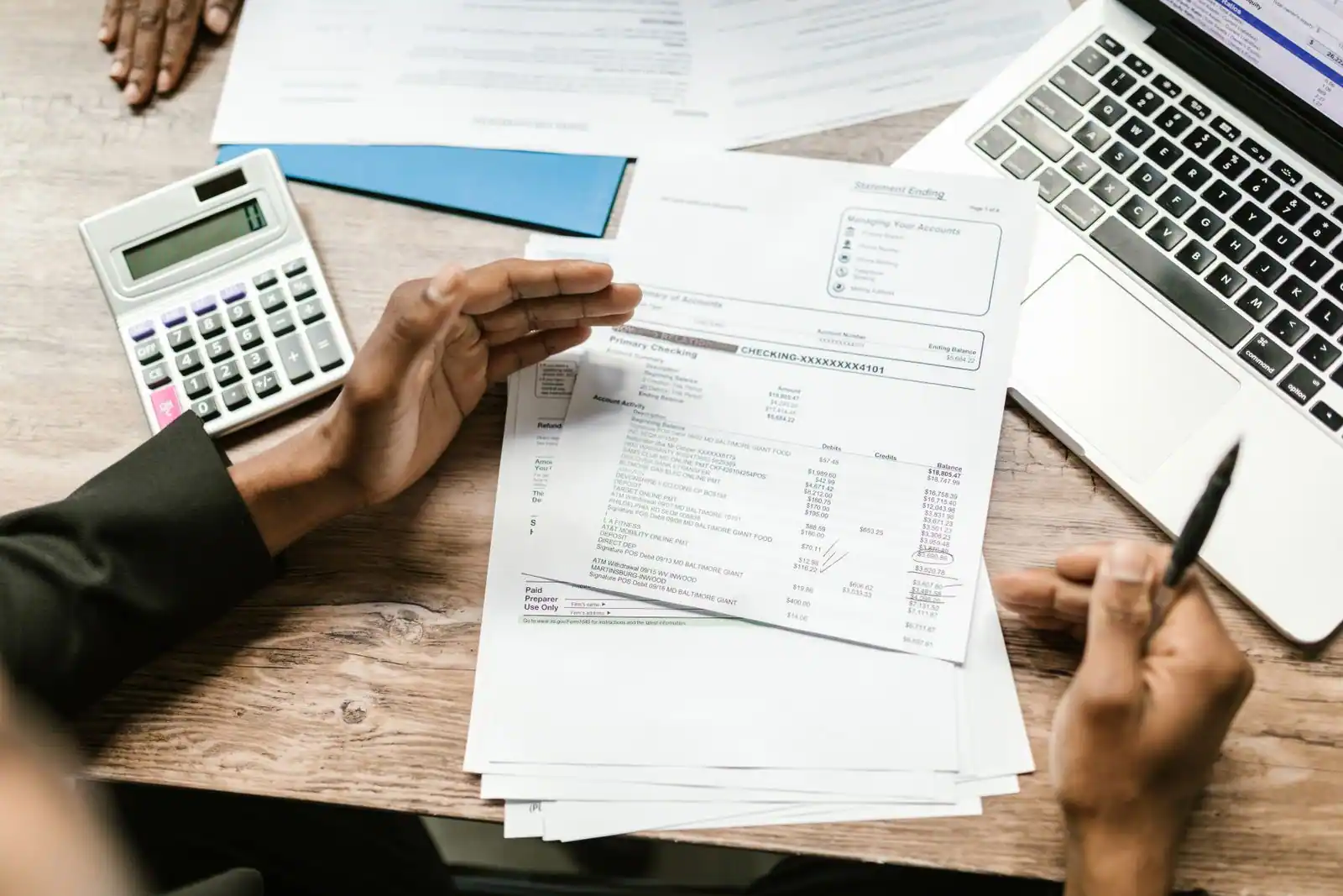 Dirigeant étudiant des documents financiers avec une calculatrice à son bureau