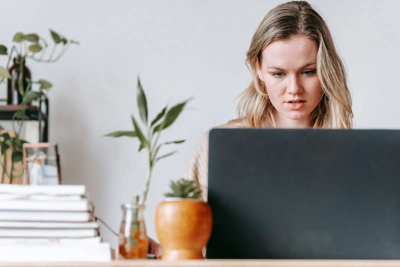 Travailleuse indépendante concentrée sur son ordinateur portable dans un espace de travail lumineux