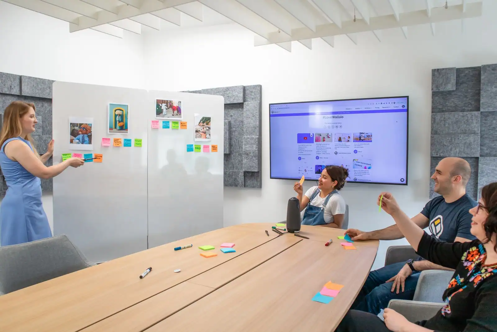 Une équipe planifie un projet avec des notes autocollantes sur un tableau blanc, dans un bureau.