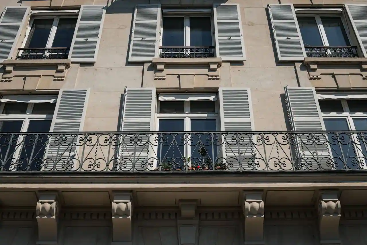 Façade d'immeuble parisien avec balcons en fer forgé et toits en zinc typiques