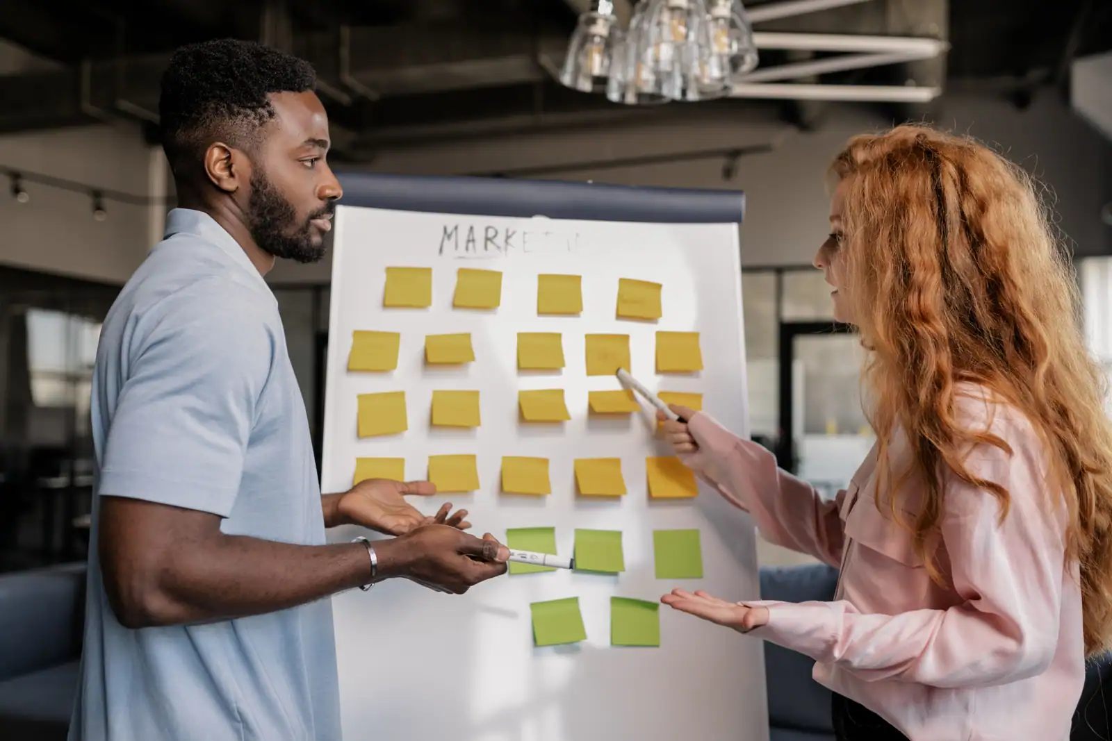 Équipe en pleine séance de brainstorming autour d'une stratégie marketing dans un bureau moderne.